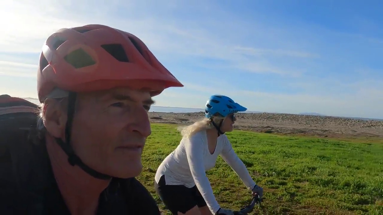 骑自行车的情侣沿着海岸的小路骑行视频下载