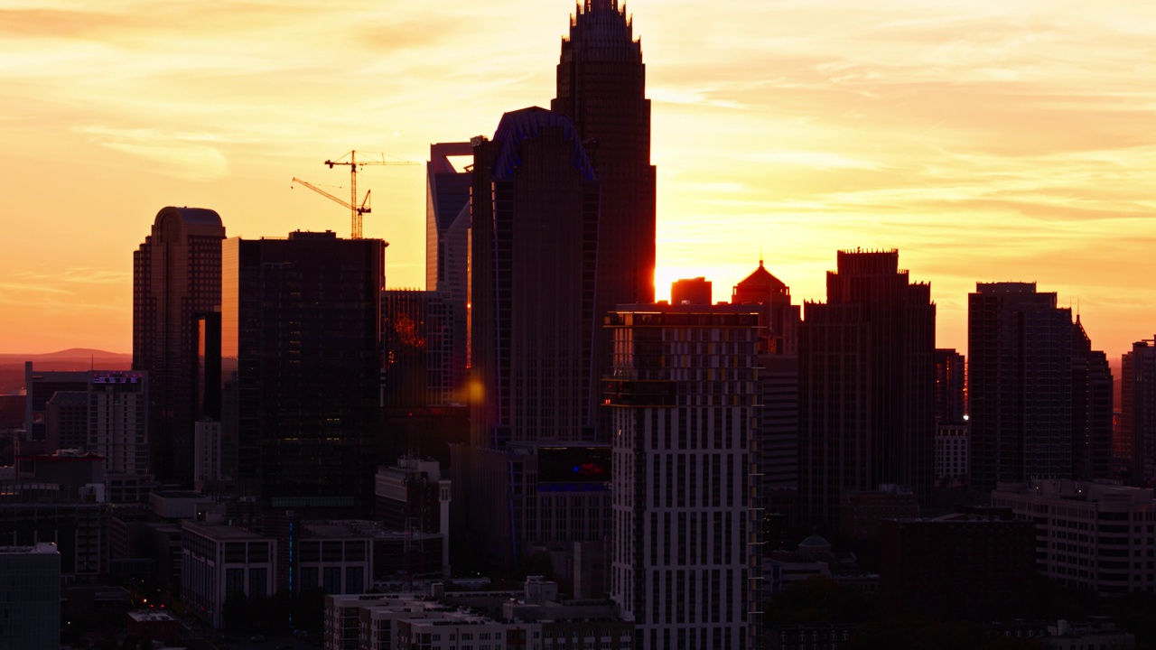 在夏洛特的摩天大楼后面落日与戏剧性镜头光晕-空中视频素材