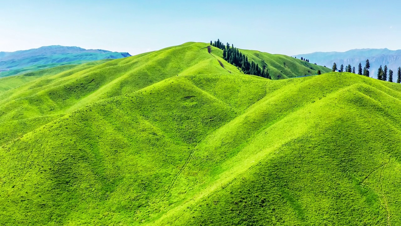 空中拍摄的新疆那拉提草原上的绿草和山地景观视频下载