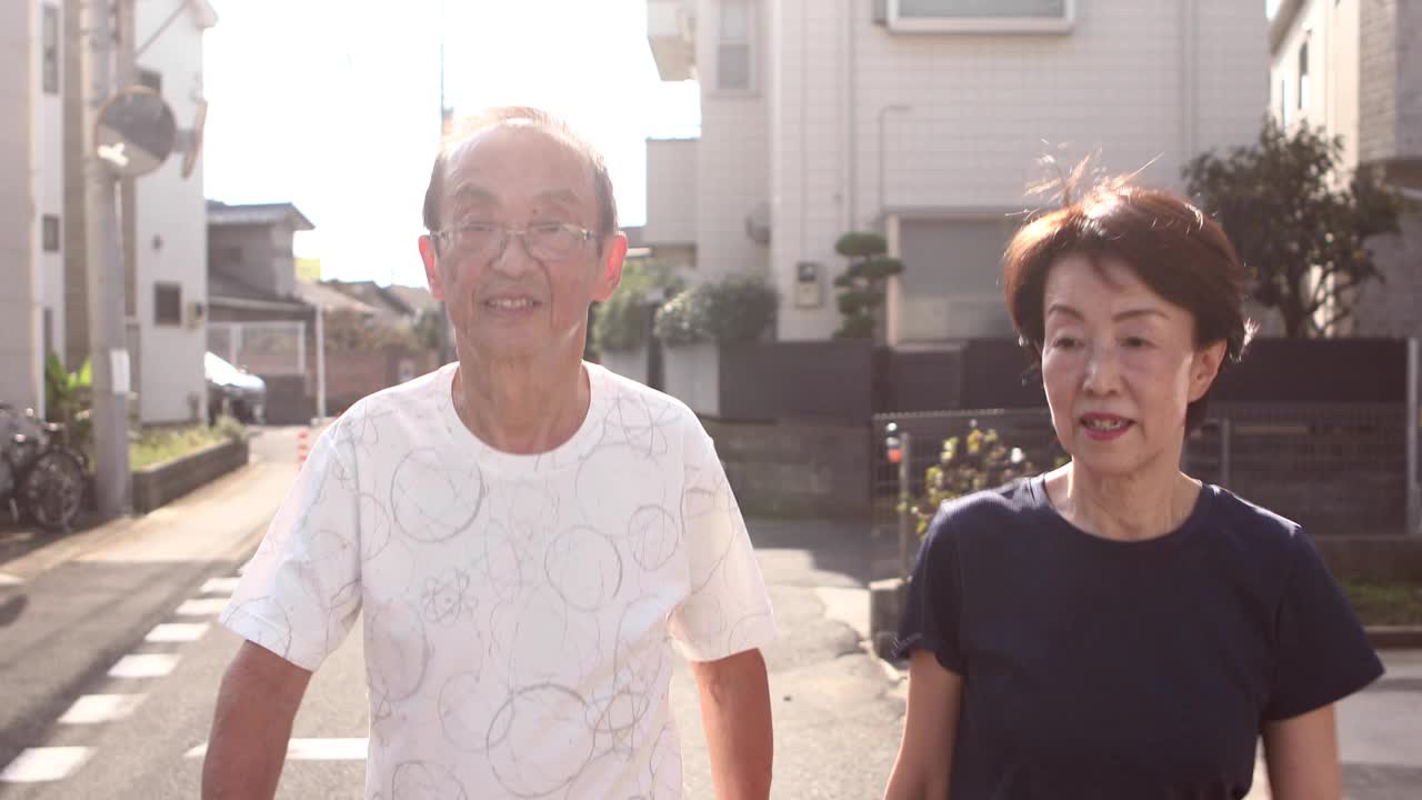 一对老年夫妇在慢跑前边走边做准备运动视频下载