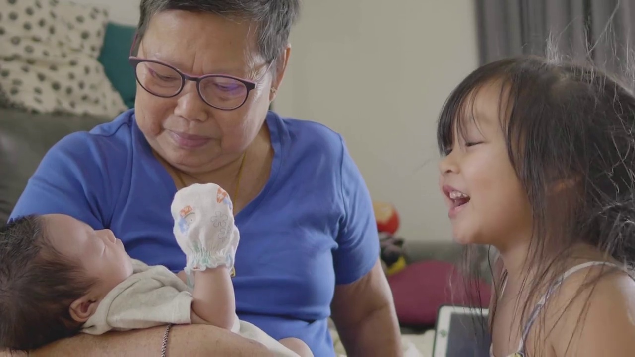 快乐的亚洲老祖母抱着一个新出生的家庭成员。坠入爱河。视频下载