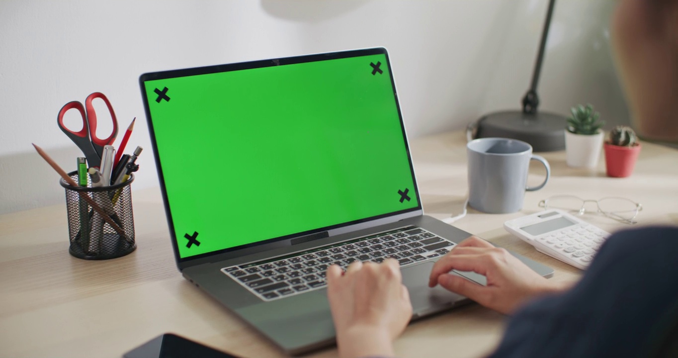 一位女士正在使用带有绿色屏幕的笔记本电脑视频素材