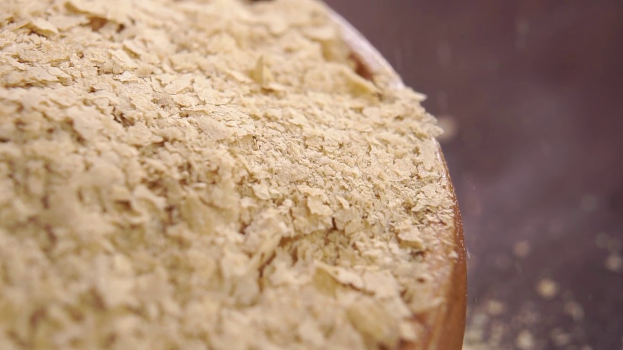 营养啤酒酵母薄片落在一个满的乡村木碗上视频下载