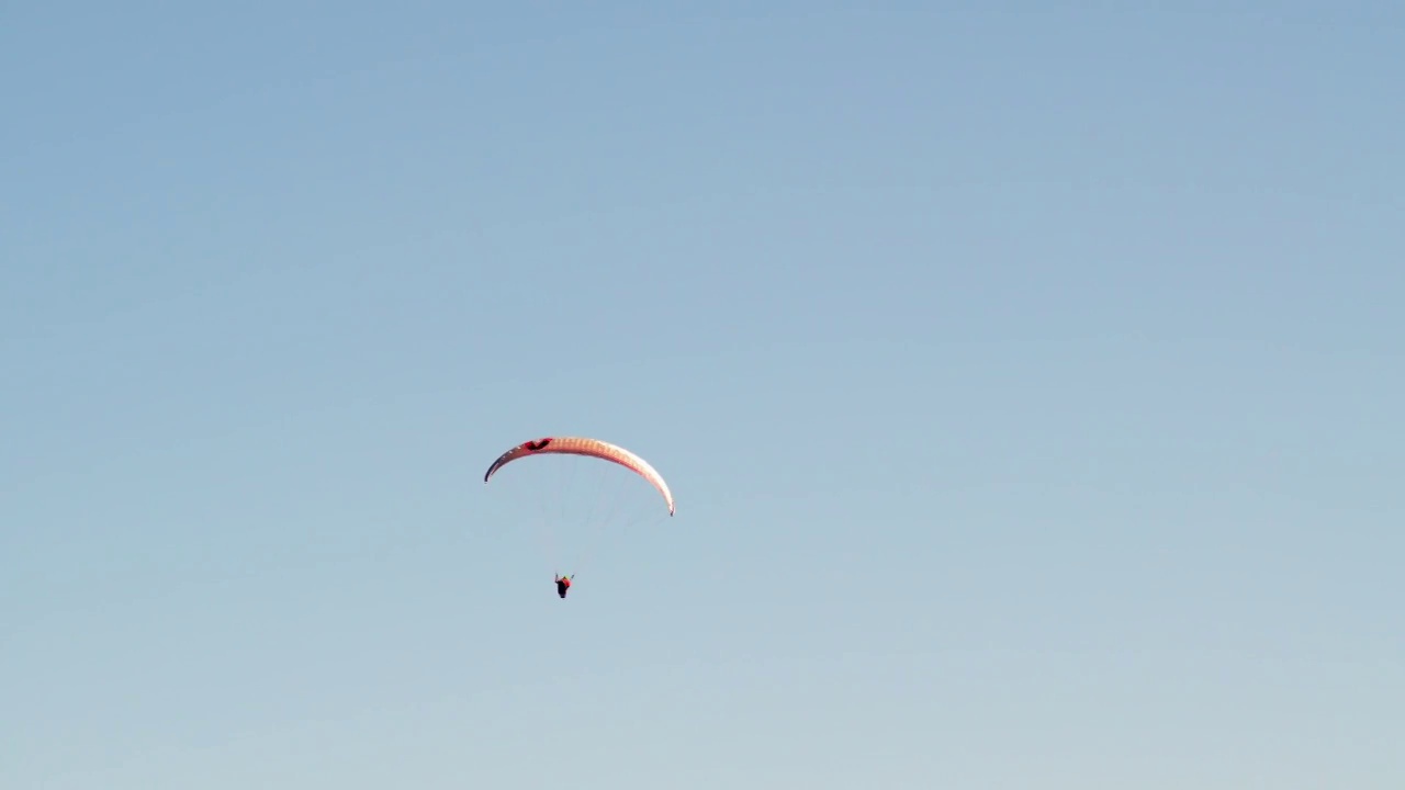 独自的滑翔伞在湛蓝的天空中翱翔。在阳光明媚的日子里，在空中滑翔，极限运动视频素材
