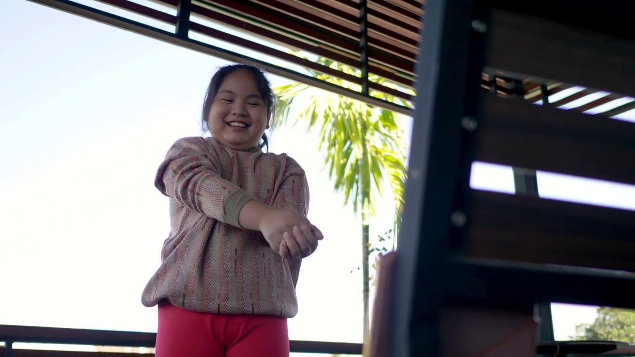 亚洲小女孩一边跳舞一边高兴地用平板电脑视频素材