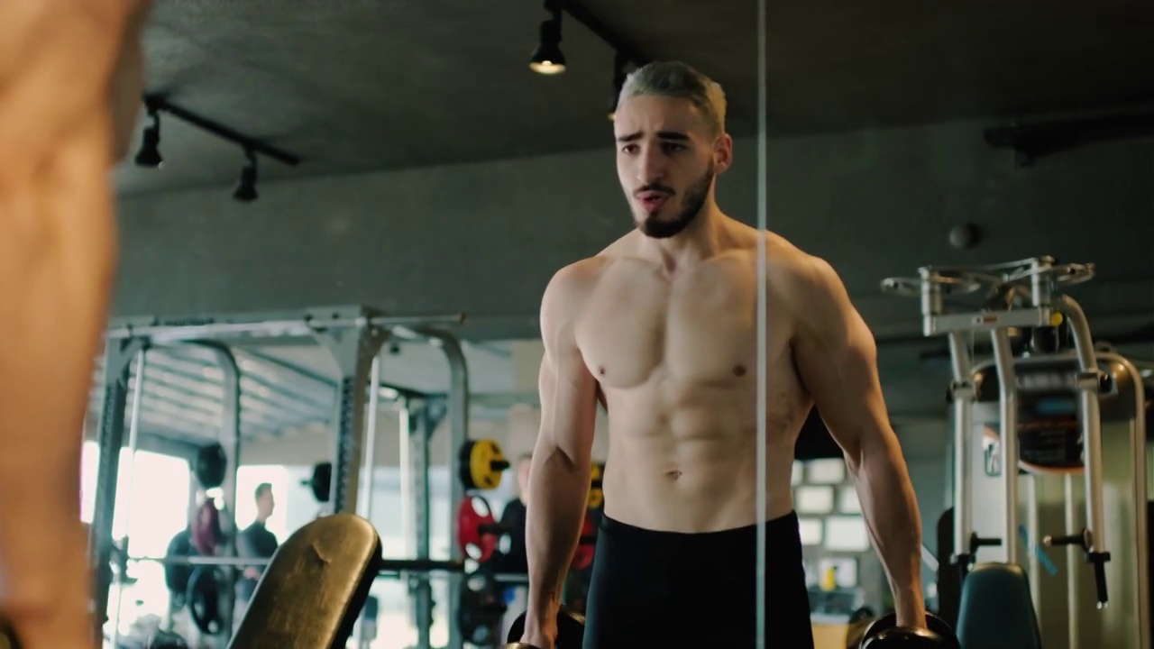 年轻的肌肉男在健身房锻炼视频下载
