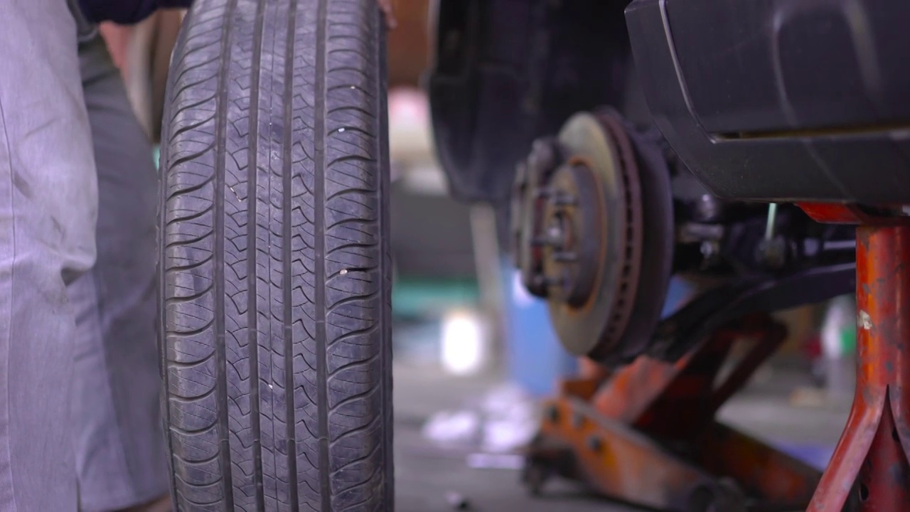 机械师在汽车修理店换轮胎视频下载