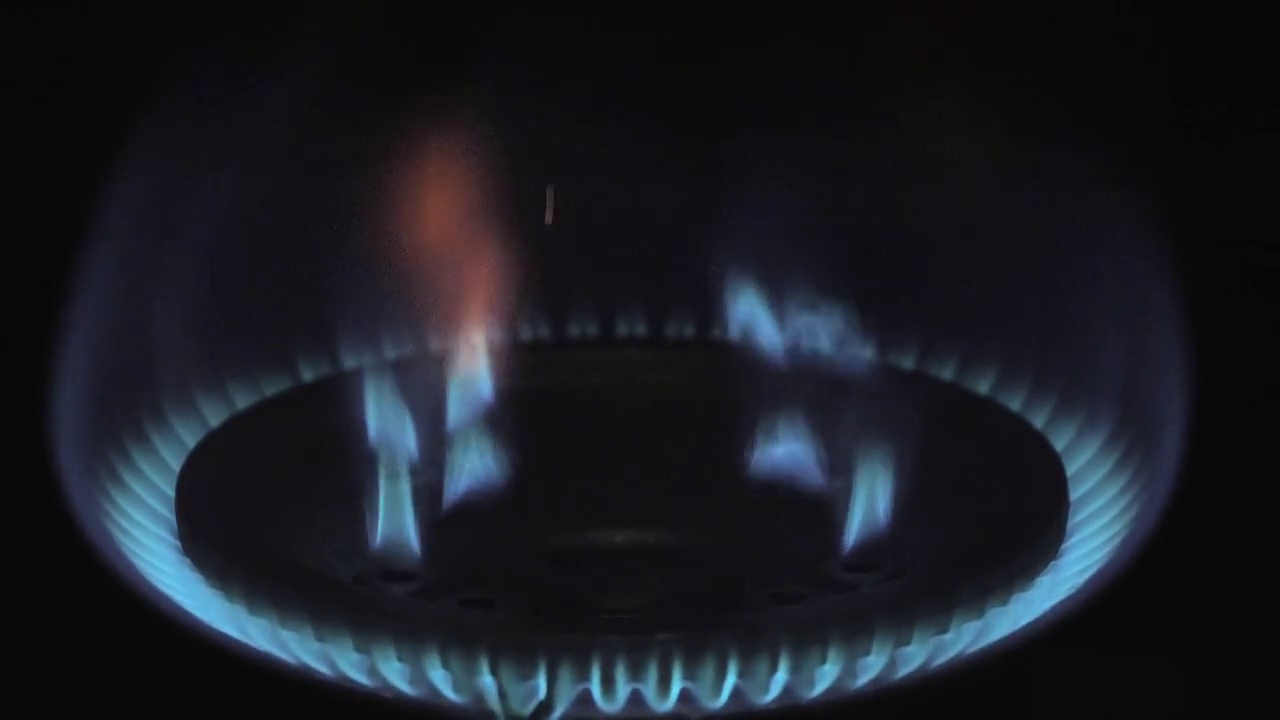 从煤气炉上近距离观察火焰不断上涨的能源价格。视频下载