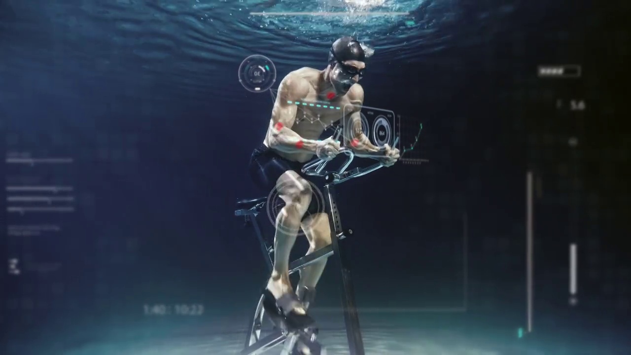 年轻男性运动员在固定的自行车机上锻炼的电影镜头，最新的创新技术增强现实全息图水下。运动、健身、沉浸式技术的概念。视频下载