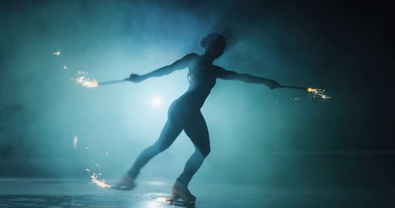 在一场比赛中，一名年轻的花样滑冰女选手正在滑冰场用烟花表演女子单滑舞蹈。庆祝、节日、胜利的观念视频素材