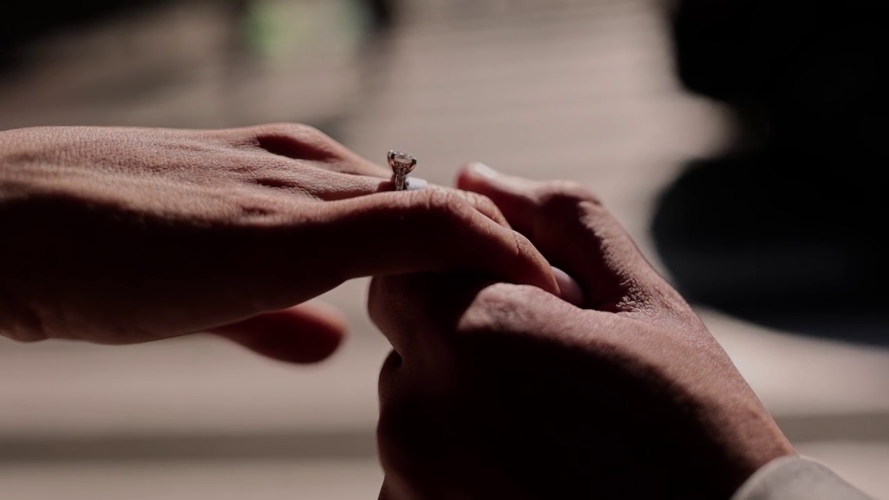 一个男人牵着一个戴着婚戒的女孩的手视频素材
