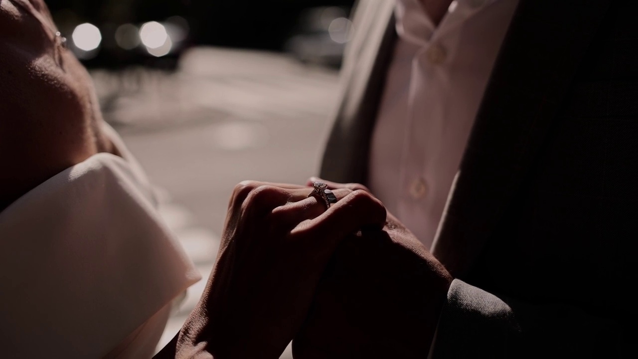 一个男人牵着一个戴着婚戒的女孩的手视频素材