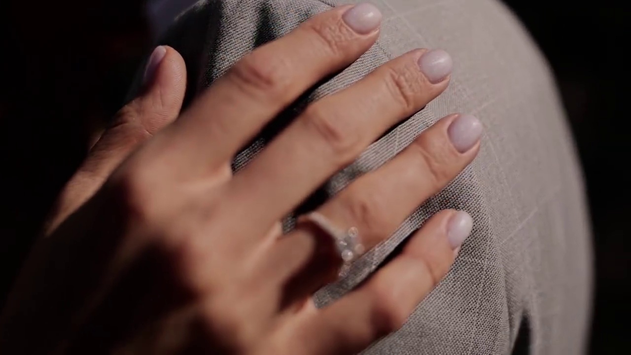 一个戴着戒指的女孩的手放在一个男人的肩膀上视频下载