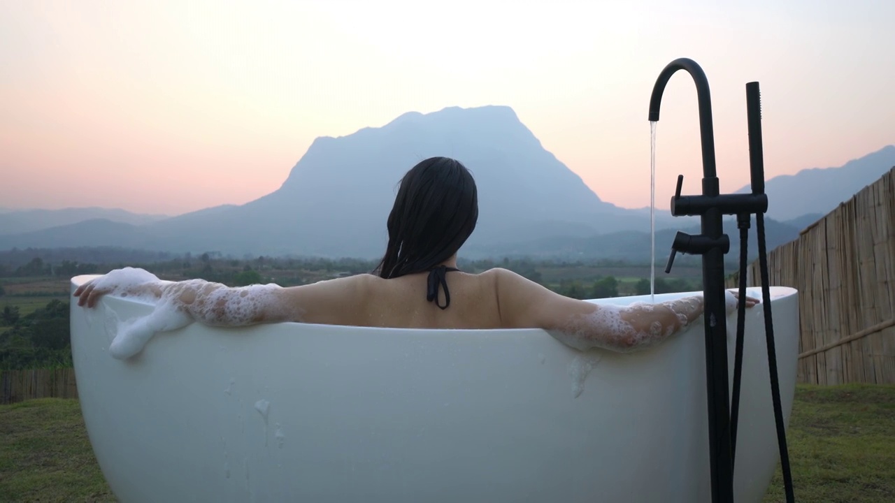 亚洲女人放松在户外沐浴与山景在前面视频下载