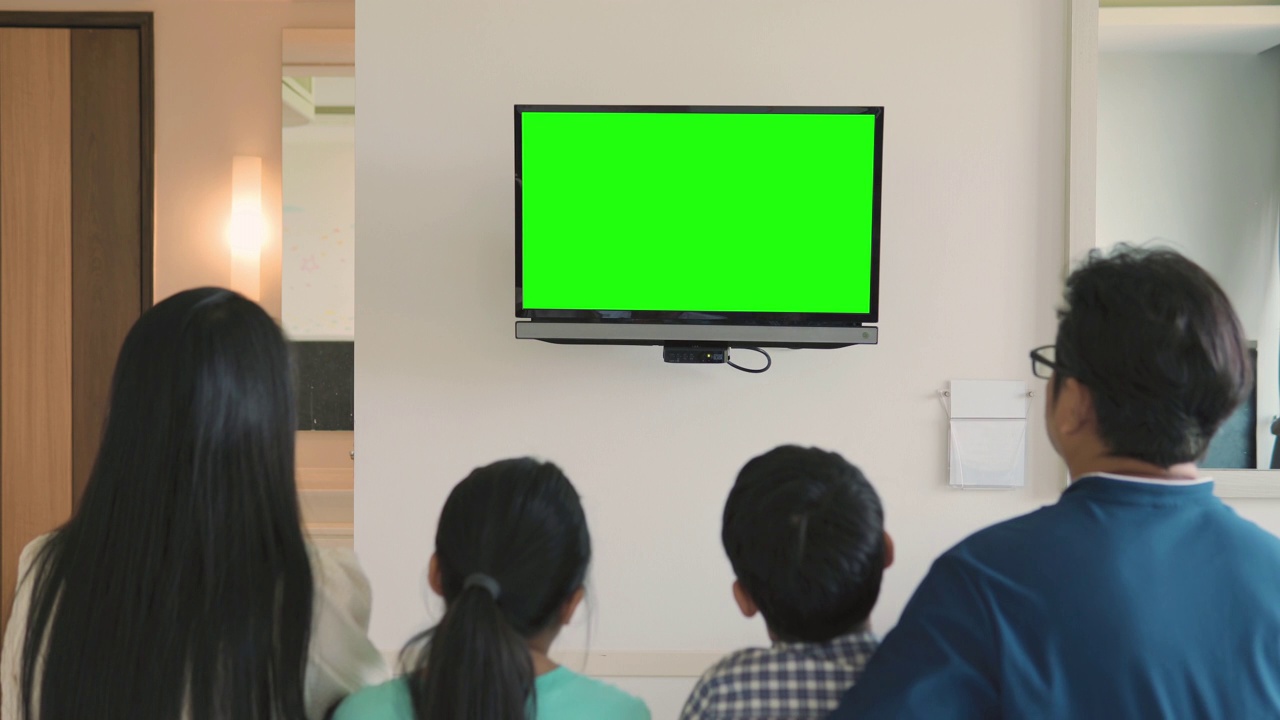 幸福的一家人坐在家里看彩色电视视频下载