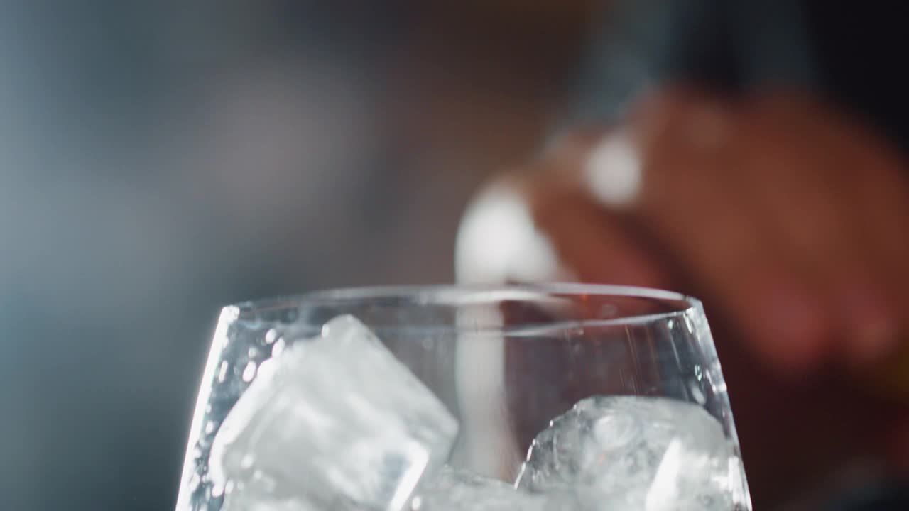 在酒吧或迪斯科舞厅，专业调酒师正在挤柠檬汁，用冰块为顾客调制酒精鸡尾酒。视频下载