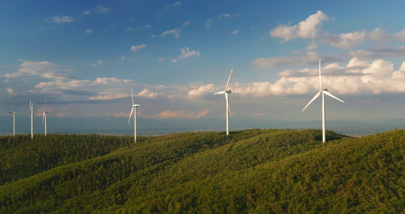 航拍风力发电机旋转的力量，并产生可再生能源的绿色生态方式，以太阳照耀地球。视频下载