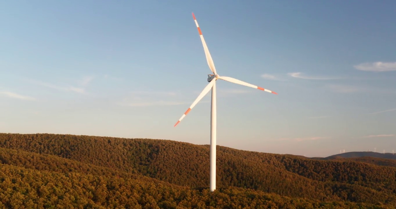 空中特写镜头，风力磨坊旋转的力量，风力和产生可再生能源的绿色生态方式，以地球上的日落。视频素材
