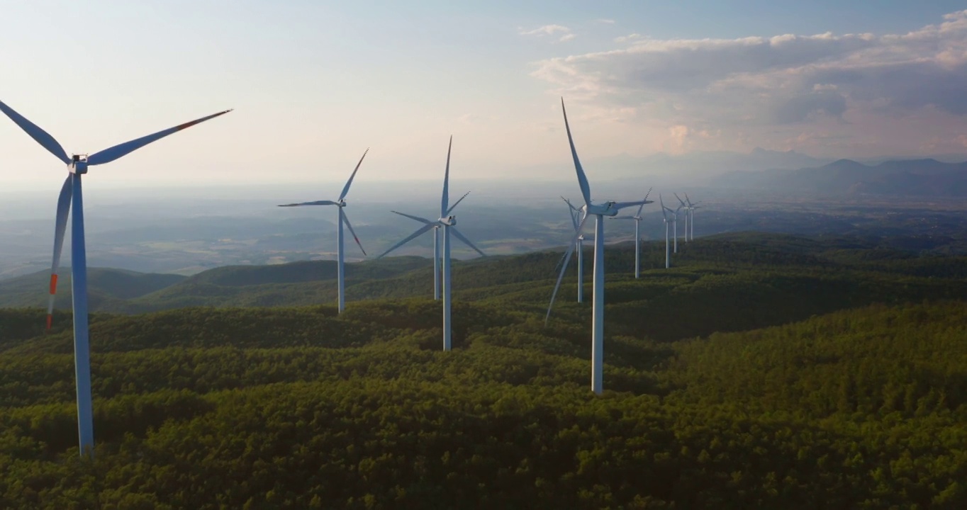 航拍风力发电机旋转的力量，并产生可再生能源的绿色生态方式，以太阳照耀地球。视频素材