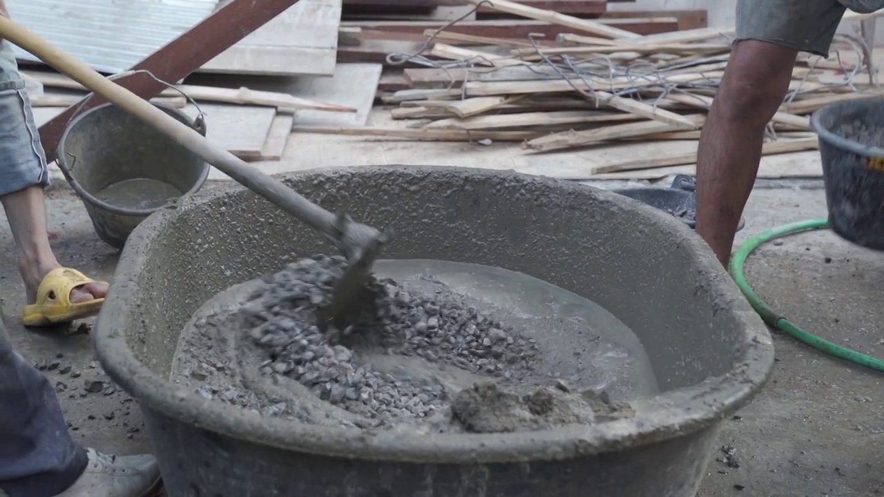 工人在施工现场搅拌和浇筑水泥。视频下载