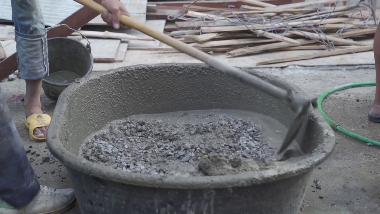 工人在施工现场搅拌和浇筑水泥。视频下载