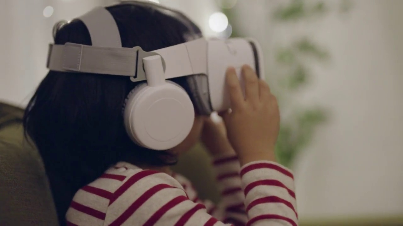 一个小男孩戴着VR头盔在家视频下载