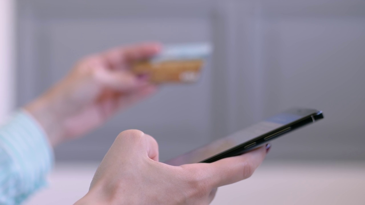 女性使用智能手机和信用卡在线购物-近距离侧面视图视频素材