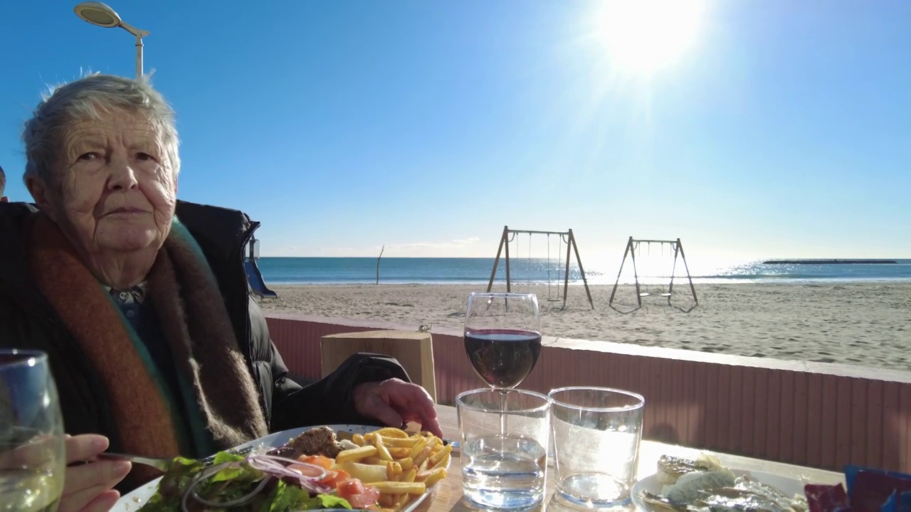 一位老妇人在海滩前的餐馆吃饭视频下载