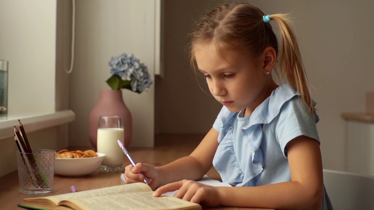 特写严肃聪明的白种人学前学校的女孩在家里坐在书桌旁的窗户学习。视频素材