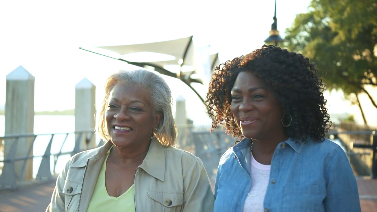 年长的非裔美国妇女走在城市海滨视频素材