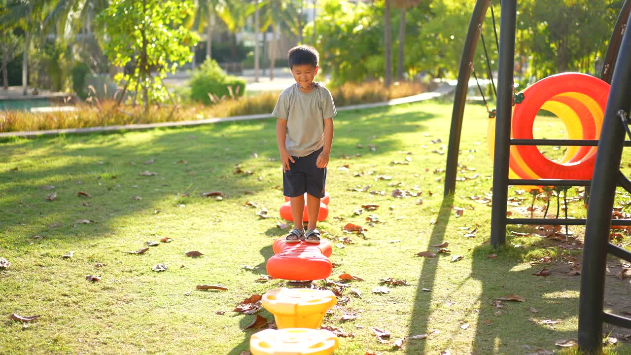 亚洲孩子在户外操场玩秋千和活动。户外学习和快乐的概念视频素材