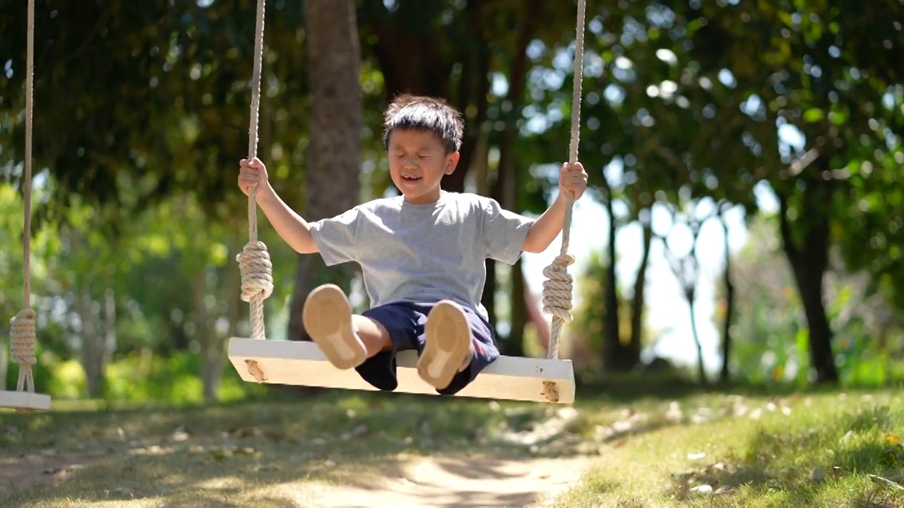 亚洲孩子在户外操场玩秋千和其他活动。户外学习与快乐的理念视频下载