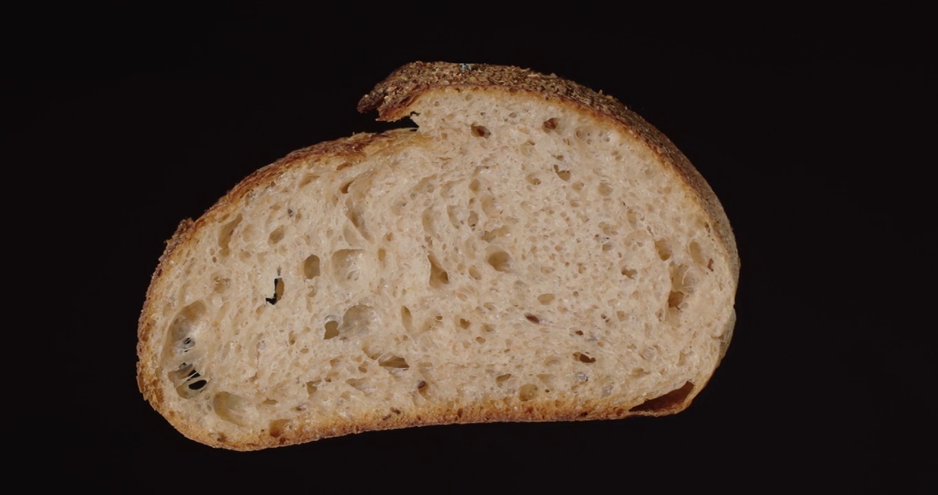 亚麻籽面包，切片。在黑色背景上旋转。视频素材