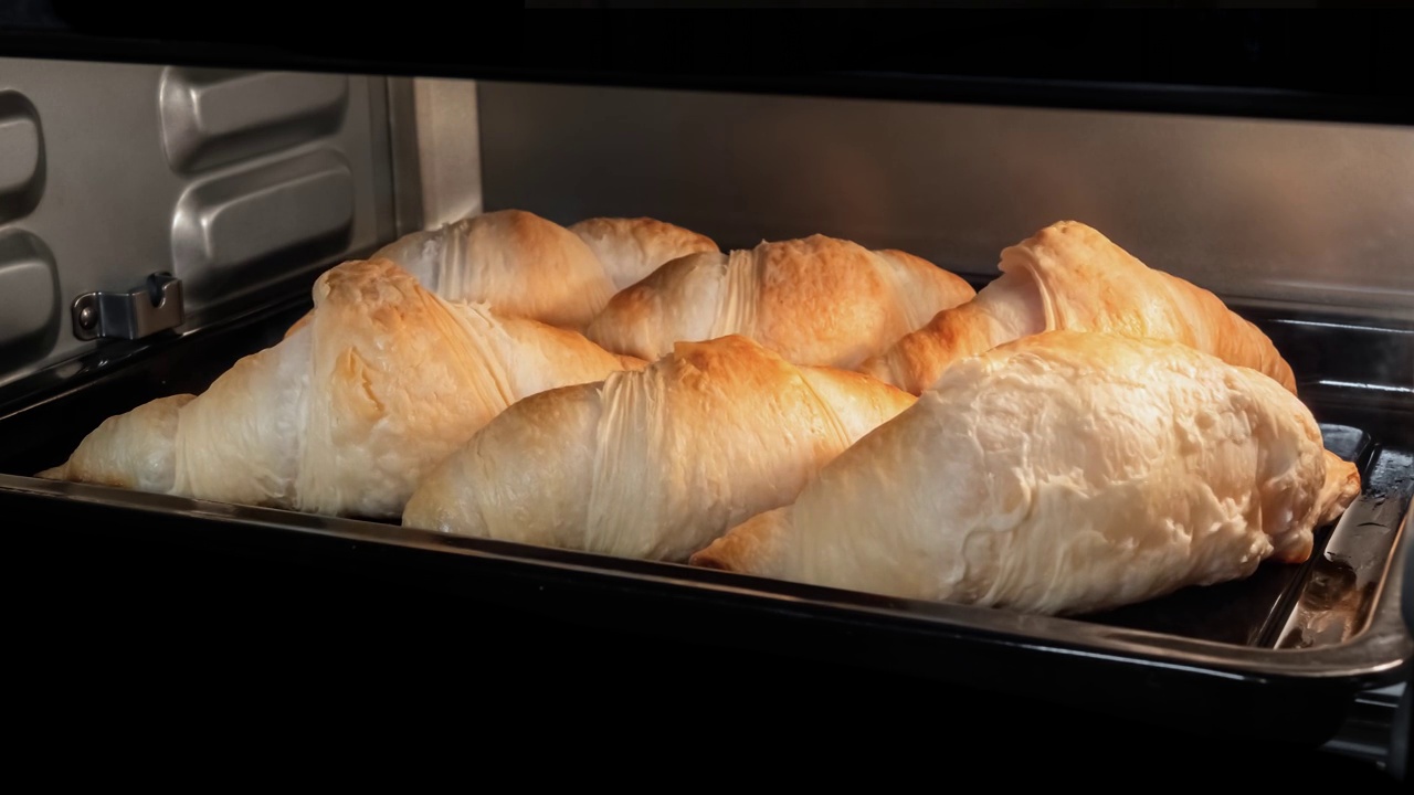 时间推移-六个自制牛角面包烘烤和上升在家里的电烤箱视频素材