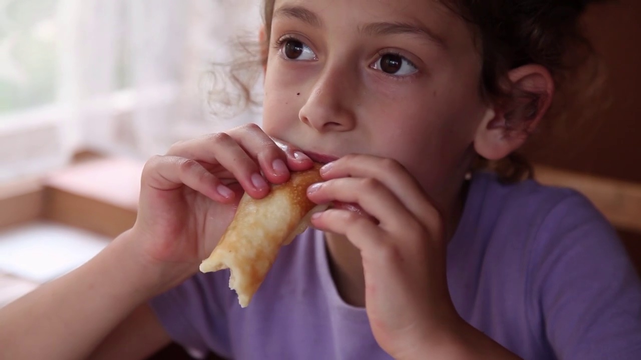 一个小女孩吃煎饼的特写视频素材