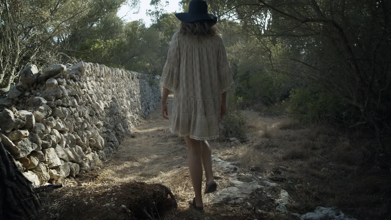 360度拍摄的一个女人走在自由飘逸的裙子和帽子视频下载