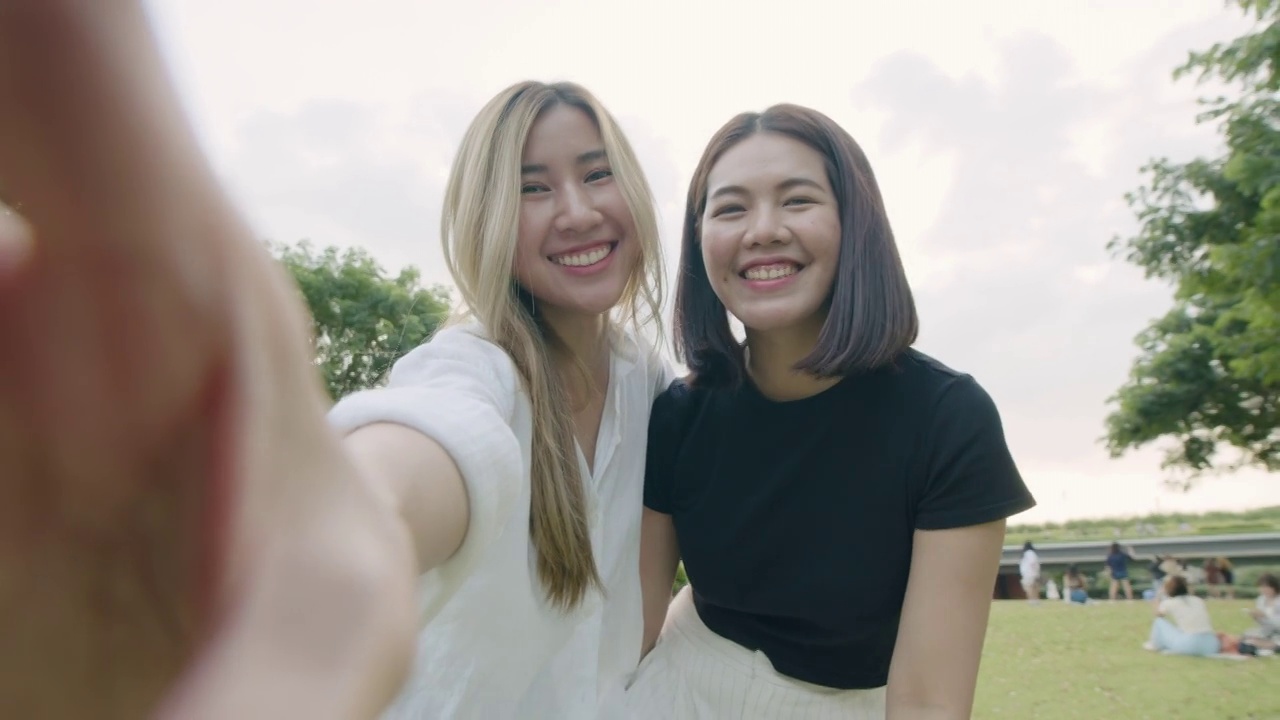 两个年轻的女性朋友在智能手机上自拍和视频通话，享受度假旅行。视频素材