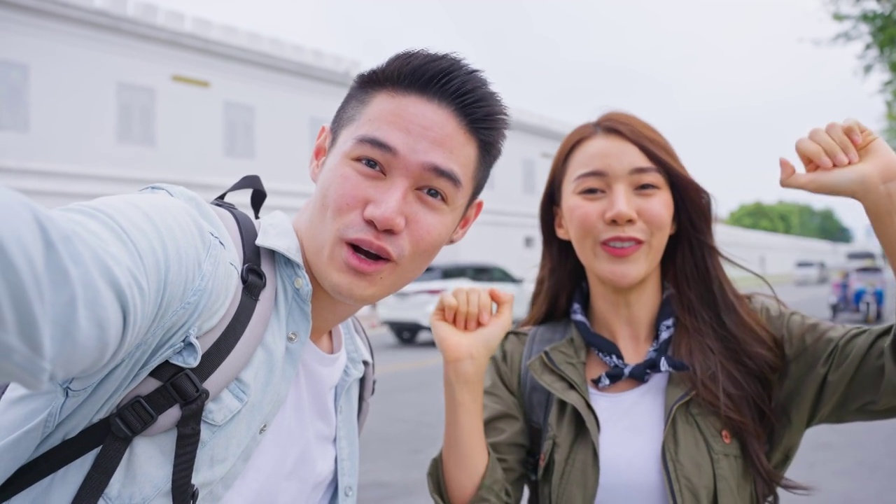 POV亚洲夫妇背包客用手机在城市拍摄视频剪辑。有魅力的男女游客在街上旅行，用智能手机录视频，在泰国度假旅行。视频下载