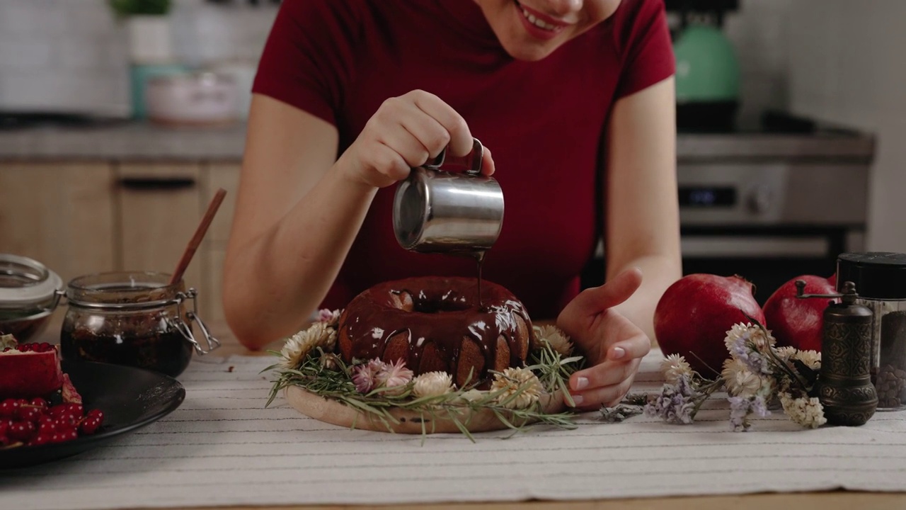 年轻的糖果师在厨房用巧克力装饰蛋糕视频下载