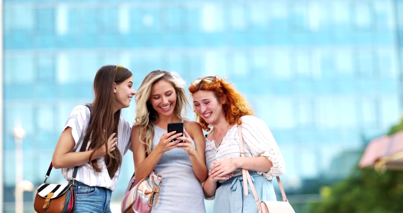 快乐的女人在城市街道上用手机聊天。视频素材