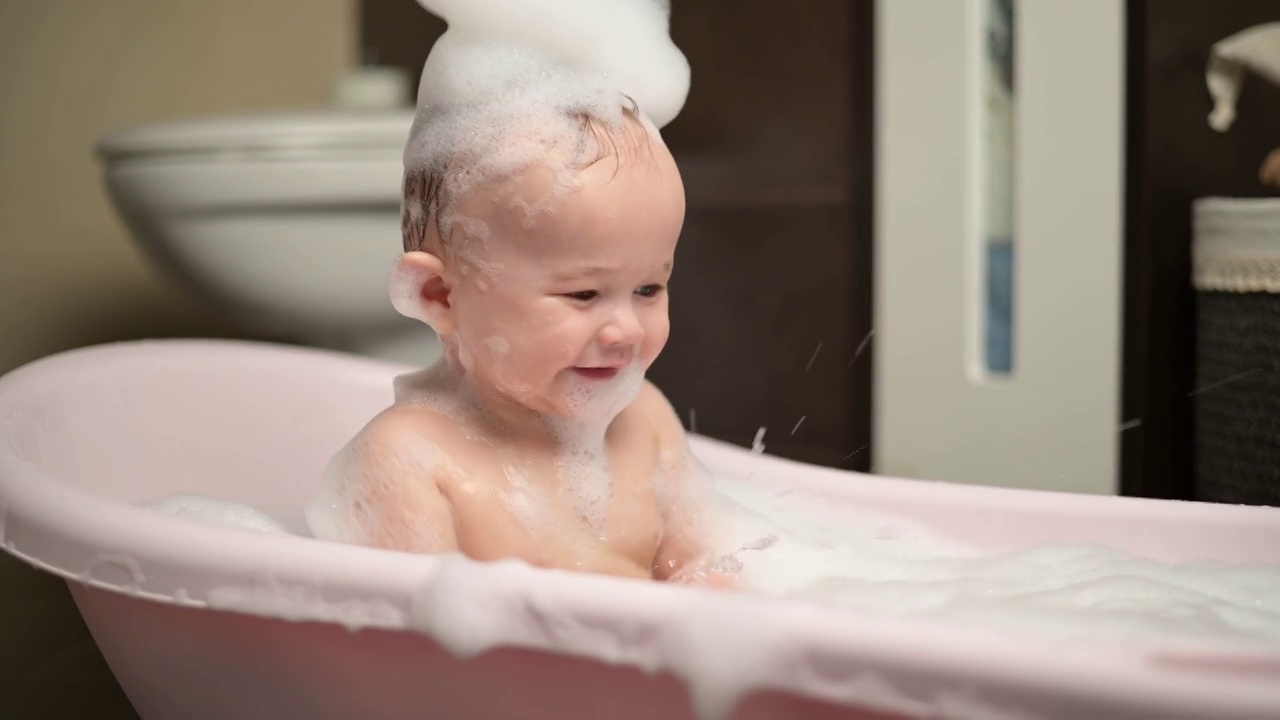 一个小男孩在泡泡浴里泼水视频素材