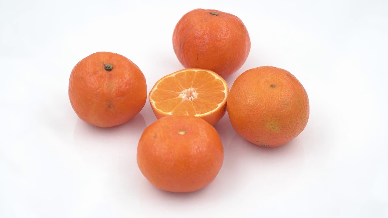 新鲜的湿橘子在白色盘子旋转背景。俯视图视频下载