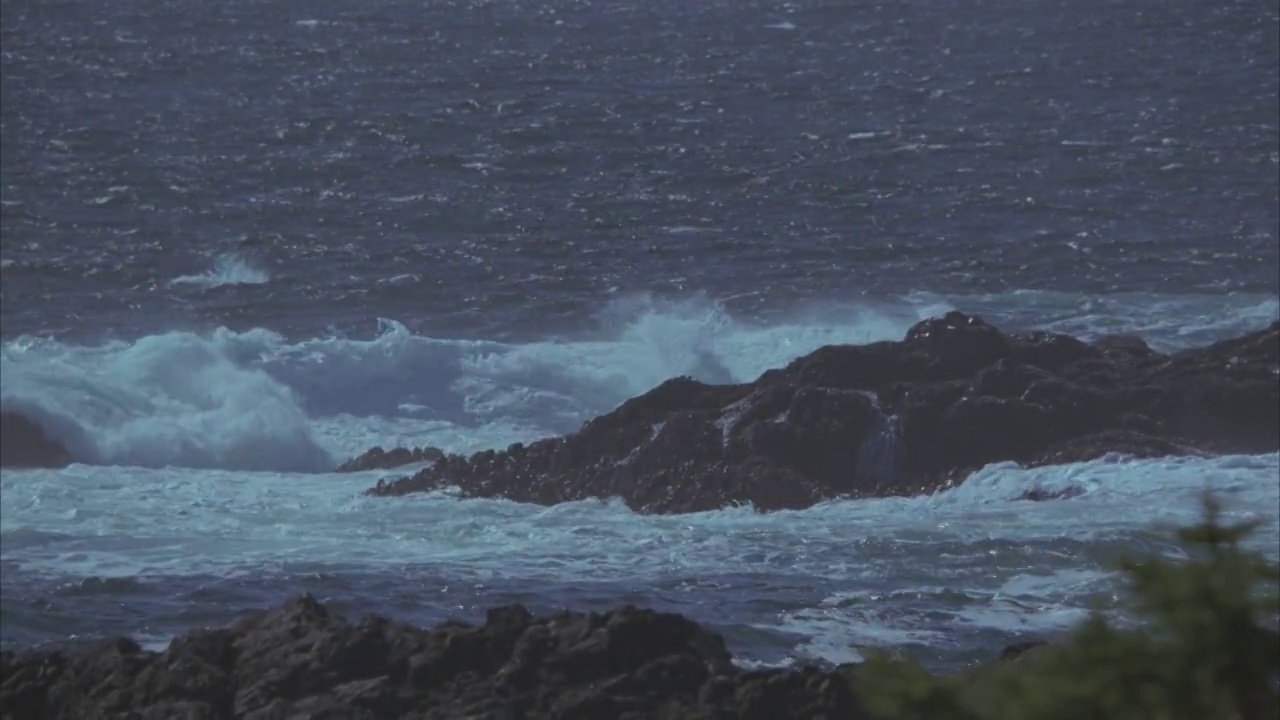 中等角度的崎岖海岸线。海浪拍打着岩石。60 FPS。视频素材