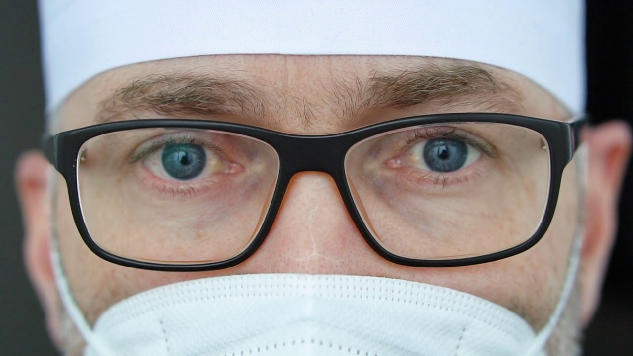 疲惫严重的成熟男性专业医生戴着口罩、眼镜和防护服，接走了大量因冠状病毒疫情而感染的患者视频素材