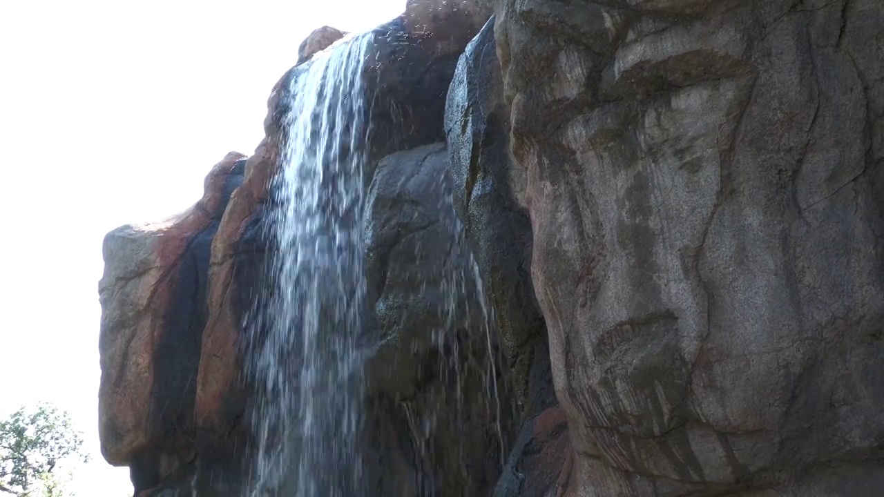 水从一块大石头顶上像瀑布一样泻下视频素材