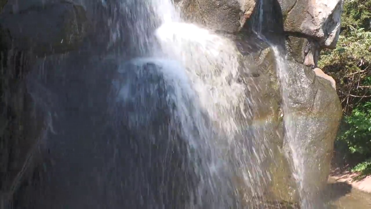 在人造瀑布中，水从岩石上倾泻而下的特写镜头视频素材
