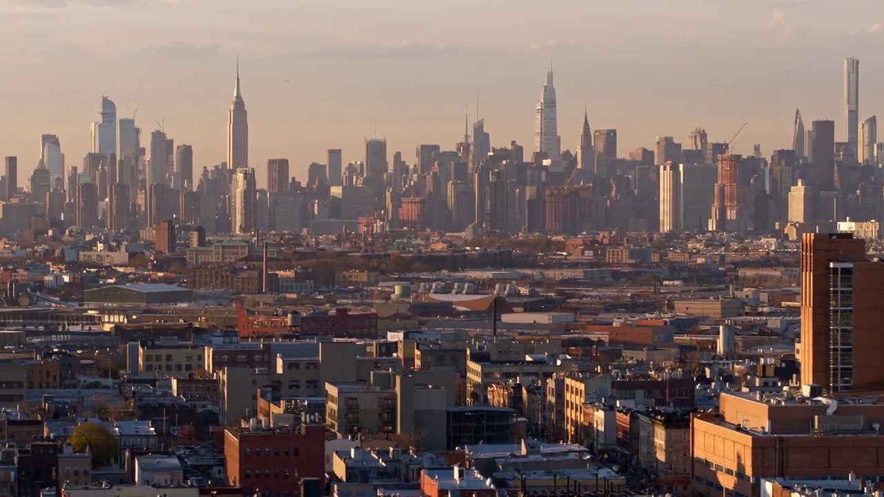 在阳光明媚的傍晚，俯瞰纽约布鲁克林布什维克住宅区的曼哈顿中城。无人机视频与平移摄像机运动。视频下载