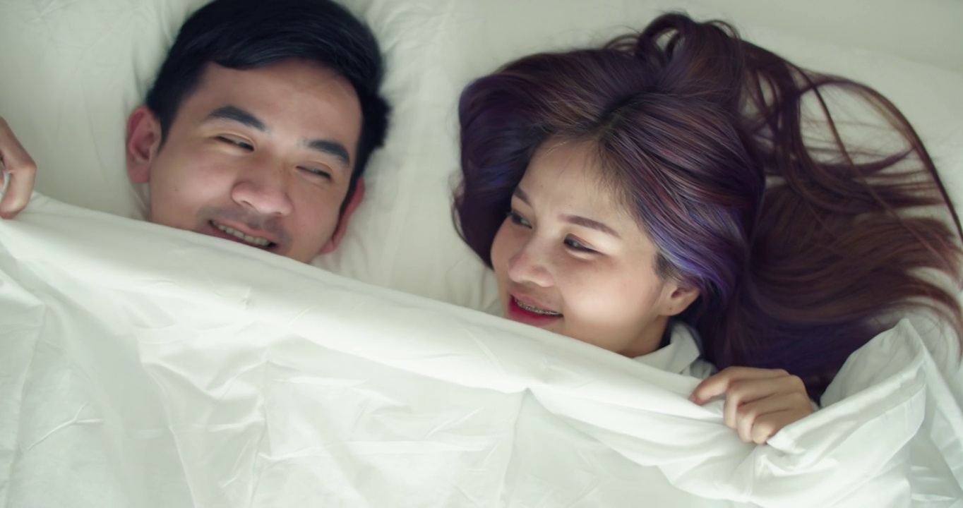 快乐的亚洲丈夫和怀孕的妻子花时间在卧室在早上。视频素材