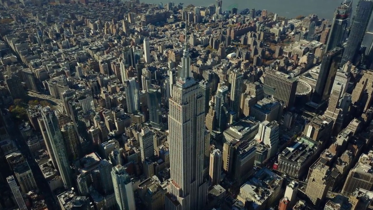城市景观的空中全景镜头。雄伟的帝国大厦高耸于周围的开发项目之上。曼哈顿，美国纽约市视频下载