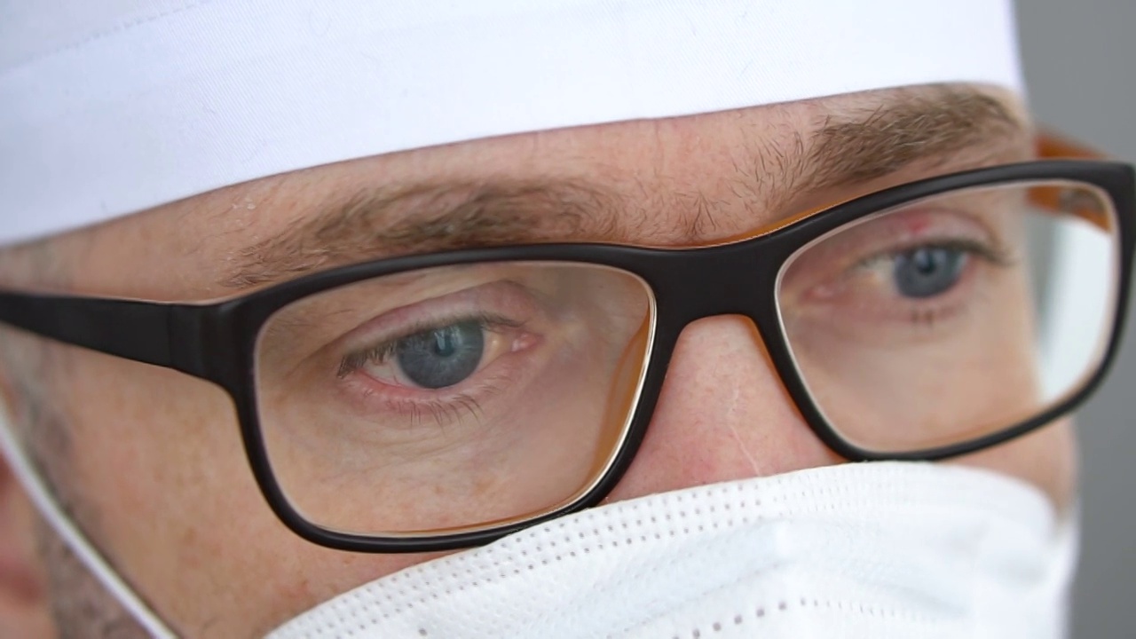 过度劳累的医护人员脸上戴着防护口罩。医疗专业人员因新冠肺炎疫情收治了大量患者后的心理状况视频素材